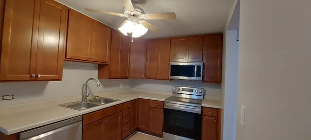 a kitchen with granite countertop stainless steel appliances a sink microwave and stove