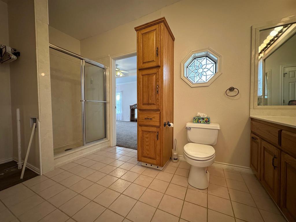 8099 Interstate 30 Frontage Road Cumby, TX 75433 - Photo 17 of 19 a bathroom with a toilet a sink and a shower