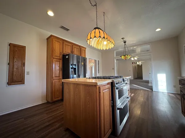 an open kitchen with wooden floor and large windows