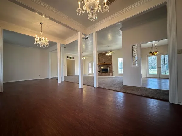 a view of a hallway with wooden floor and a chandelier