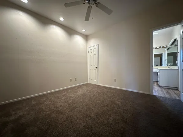 an empty room with windows and fan