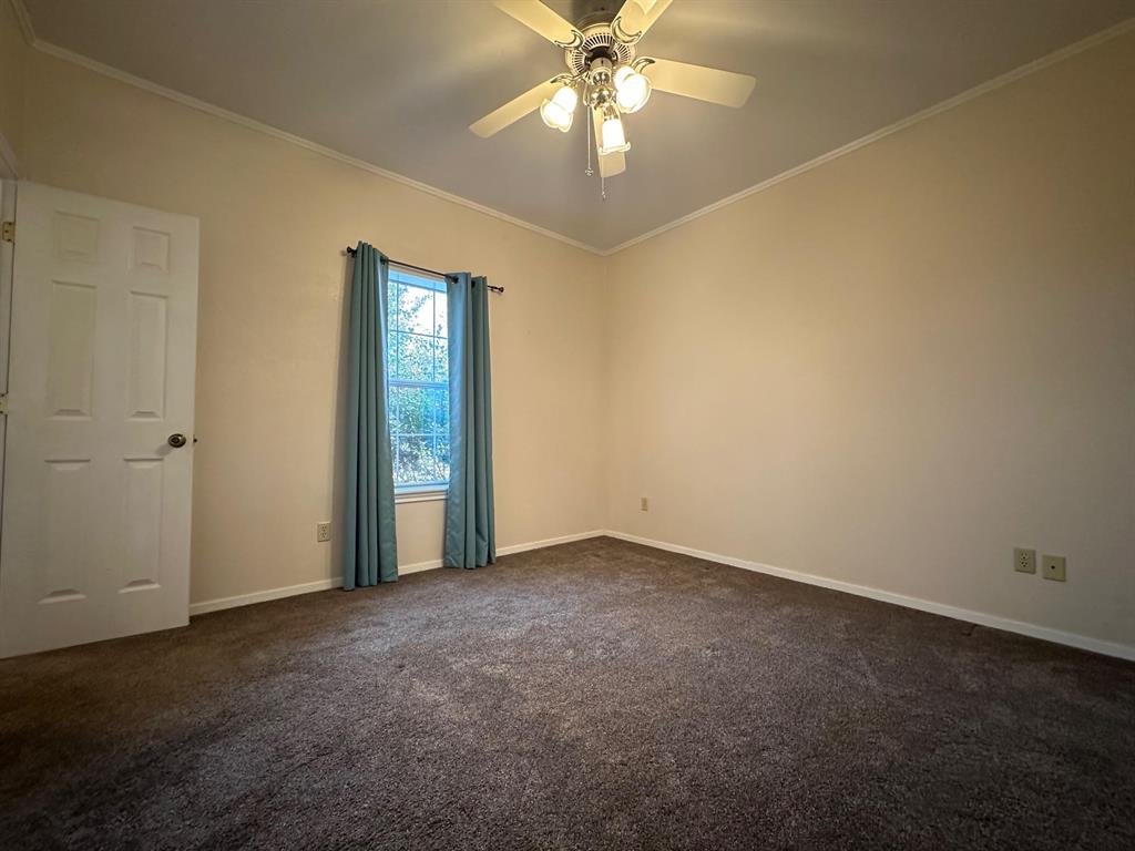 8099 Interstate 30 Frontage Road Cumby, TX 75433 - Photo 10 of 19 an empty room with a chandelier fan and windows
