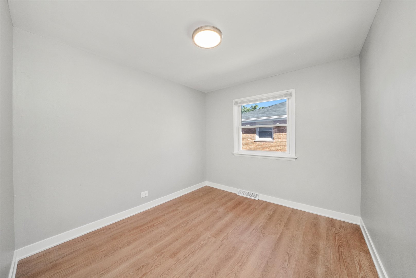 16333 Winchester Avenue Markham, IL 60428 - Photo 13 of 23 an empty room with wooden floor and windows