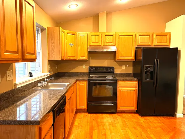 a view of a hallway with wooden floor and closet