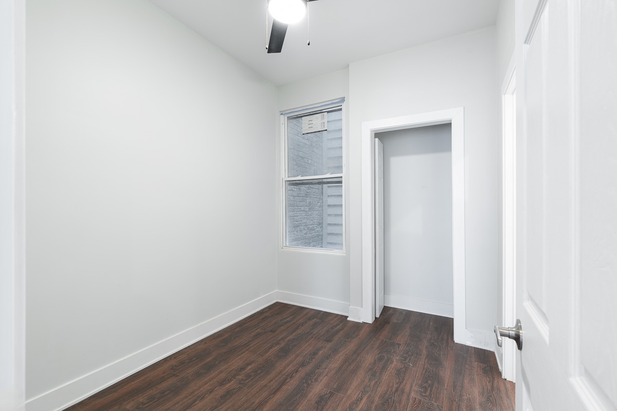 3003 West Fulton Street, Unit 1 Chicago, IL 60612 - Photo 21 of 29 an empty room with wooden floor chandelier fan and windows
