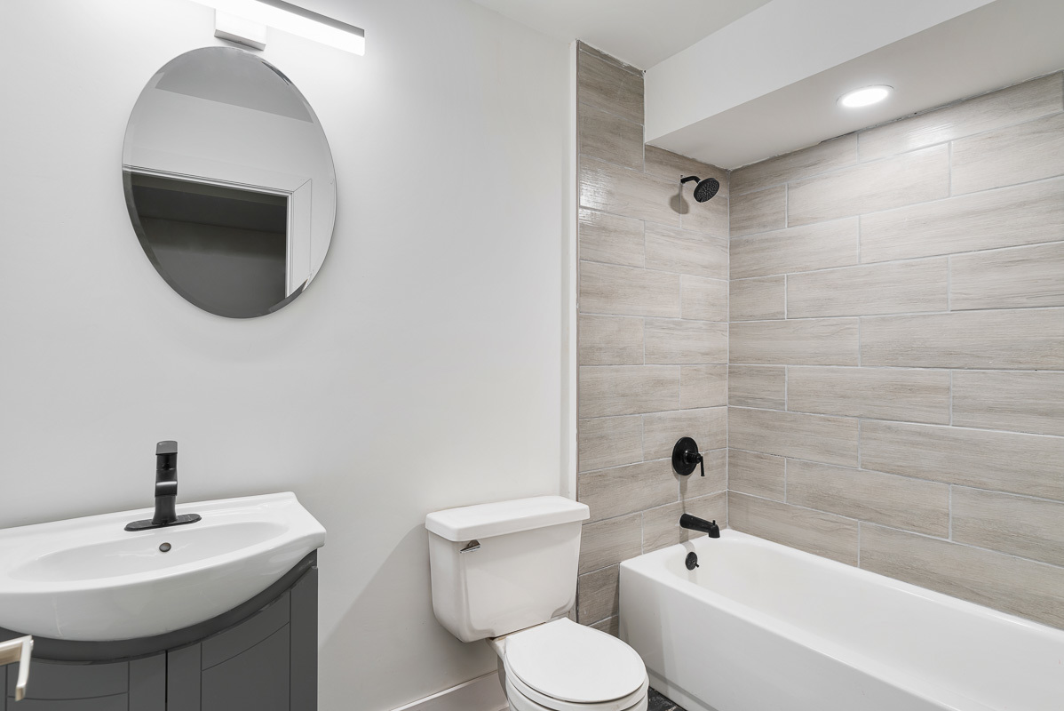 3003 West Fulton Street, Unit 1 Chicago, IL 60612 - Photo 27 of 29 a bathroom with a toilet a sink a mirror and bathtub