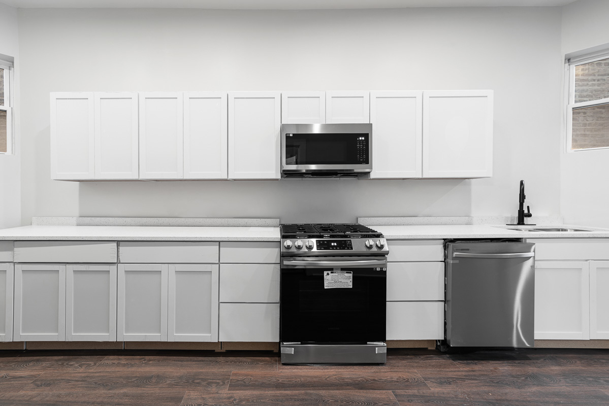 3003 West Fulton Street, Unit 1 Chicago, IL 60612 - Photo 8 of 29 a kitchen with stainless steel appliances granite countertop a stove a sink and a microwave