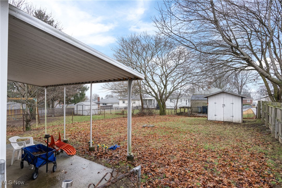 Fenced backyard with a storage shed and a patio