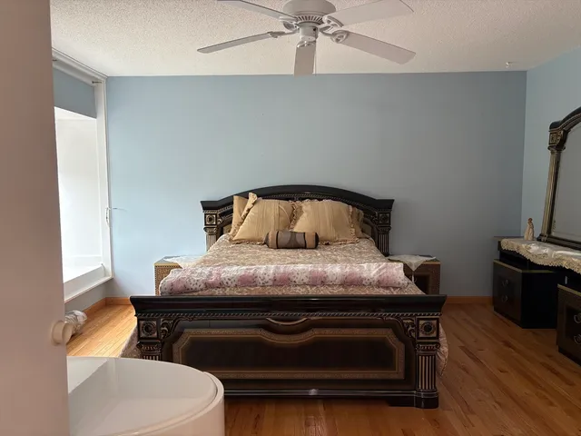 a bedroom with a bed and wooden floor