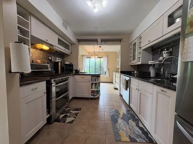 a kitchen with a sink stainless steel appliances and cabinets
