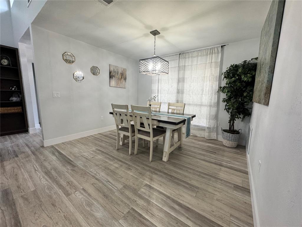 5407 Southwest 82 Terrace Gainesville, FL 32608 - Photo 11 of 31 a dining room with furniture window and wooden floor