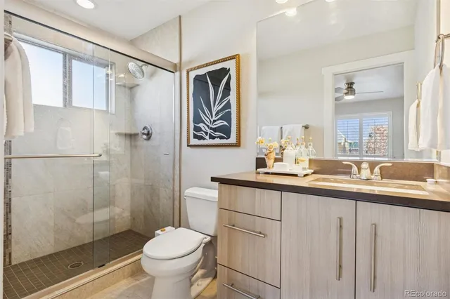 a bathroom with a granite countertop sink toilet and shower