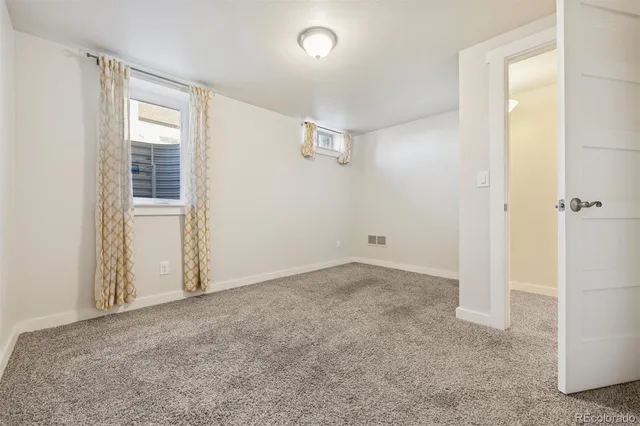 an empty room with windows and closet