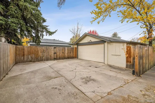 a view of backyard of house with wooden fence
