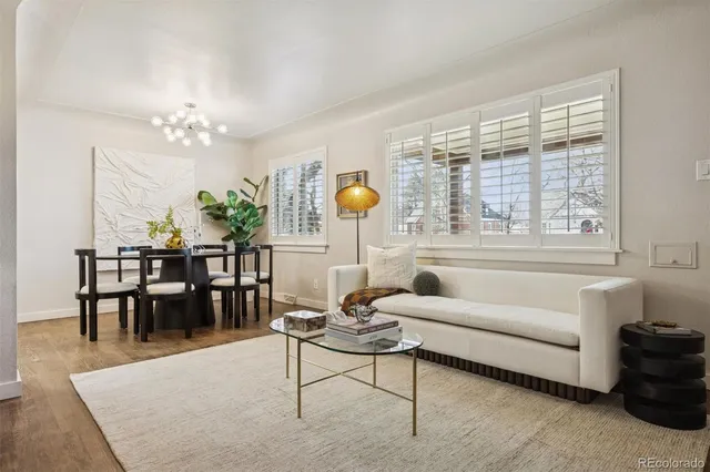 a living room with furniture a table and a large window