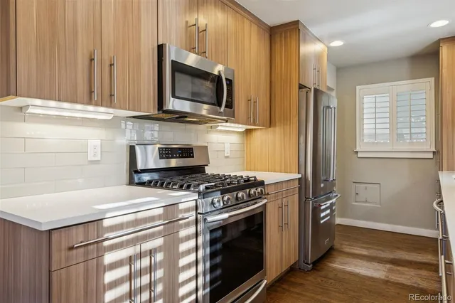 a kitchen with stainless steel appliances a stove a microwave and white cabinets