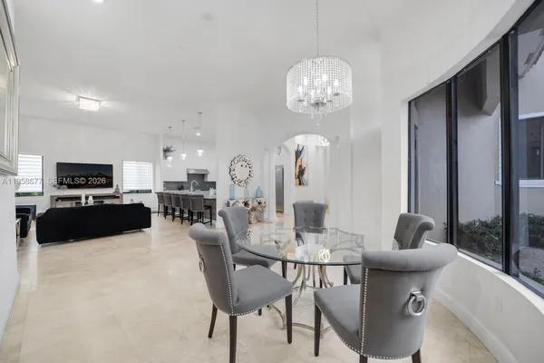 a large kitchen with kitchen island a large counter top space a sink stainless steel appliances and cabinets