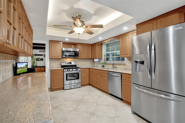 a kitchen with stainless steel appliances granite countertop a refrigerator a stove top oven a sink and dishwasher
