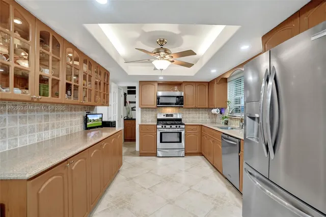 a kitchen with stainless steel appliances granite countertop a refrigerator a stove a sink dishwasher and a microwave oven with cabinets