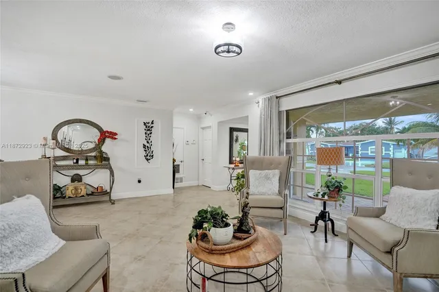 a living room with furniture a chandelier and a large window