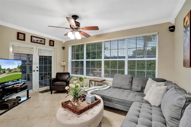 a living room with furniture ceiling fan and a window