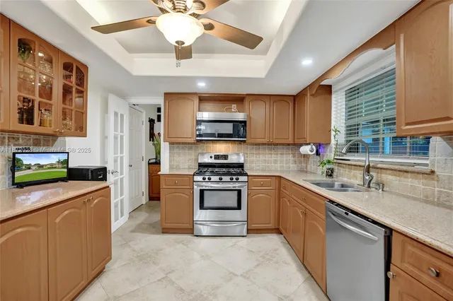 a kitchen with stainless steel appliances granite countertop a sink cabinets stove and refrigerator