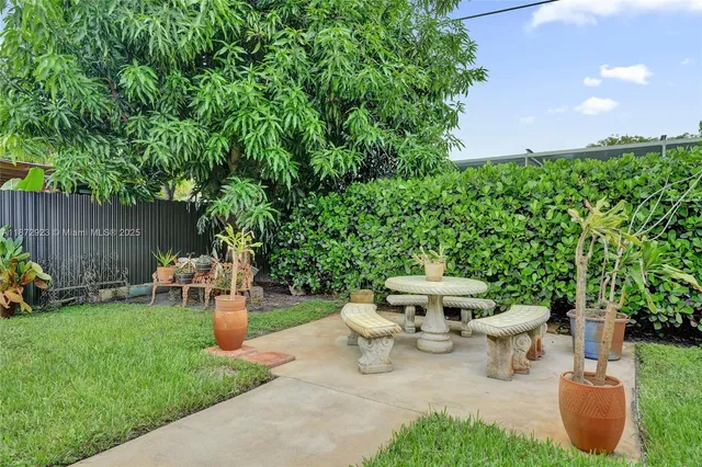 a view of a backyard with sitting area and garden