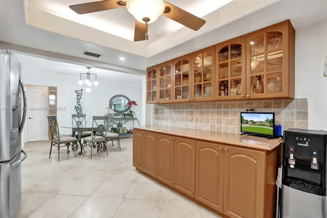 a dining hall with stainless steel appliances granite countertop a stove a sink a dining table and chairs with wooden floor