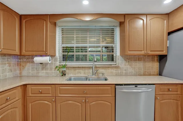 a kitchen with granite countertop cabinets sink and window