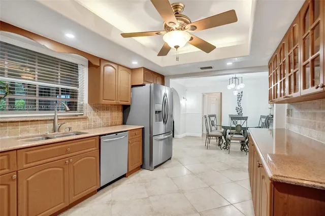 a kitchen with stainless steel appliances granite countertop a sink and a refrigerator