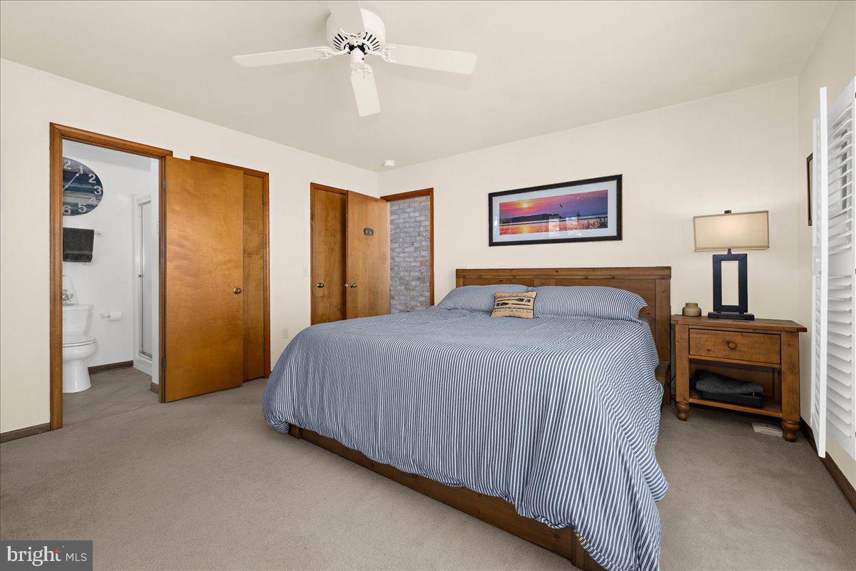 12440 Woods Road Worton, MD 21678 - Photo 13 of 37 a bedroom with a large bed and a chandelier