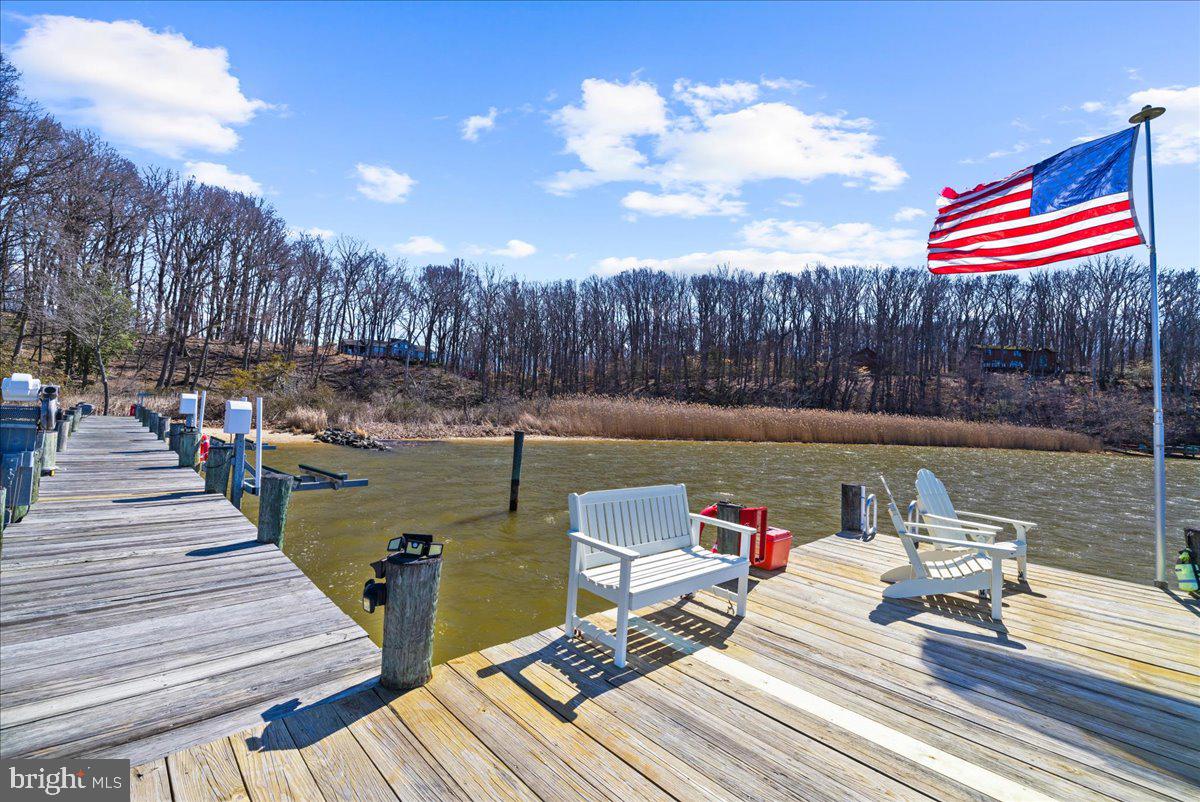 12440 Woods Road Worton, MD 21678 - Photo 5 of 37 a roof deck with table and chairs and wooden floor