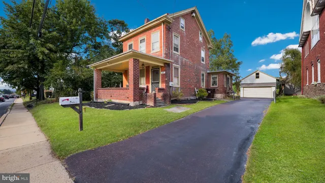 a front view of a house with a yard and tree