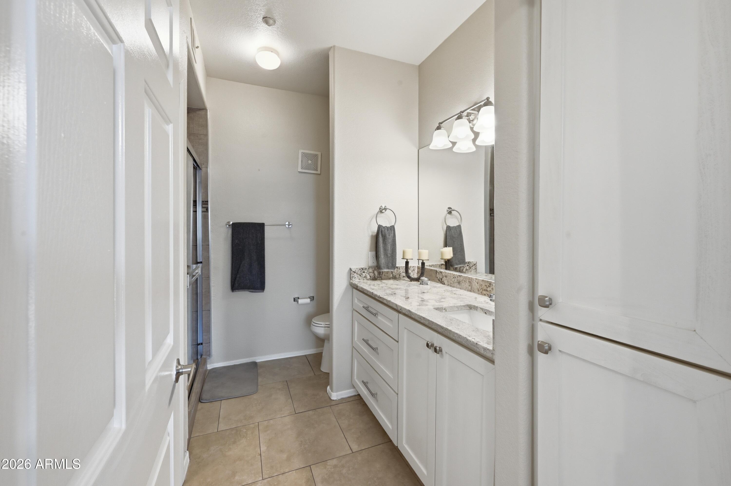 5303 North 7th Street, Unit 220 Phoenix, AZ 85014 - Photo 18 of 33 a bathroom with a granite countertop sink a mirror and a shower
