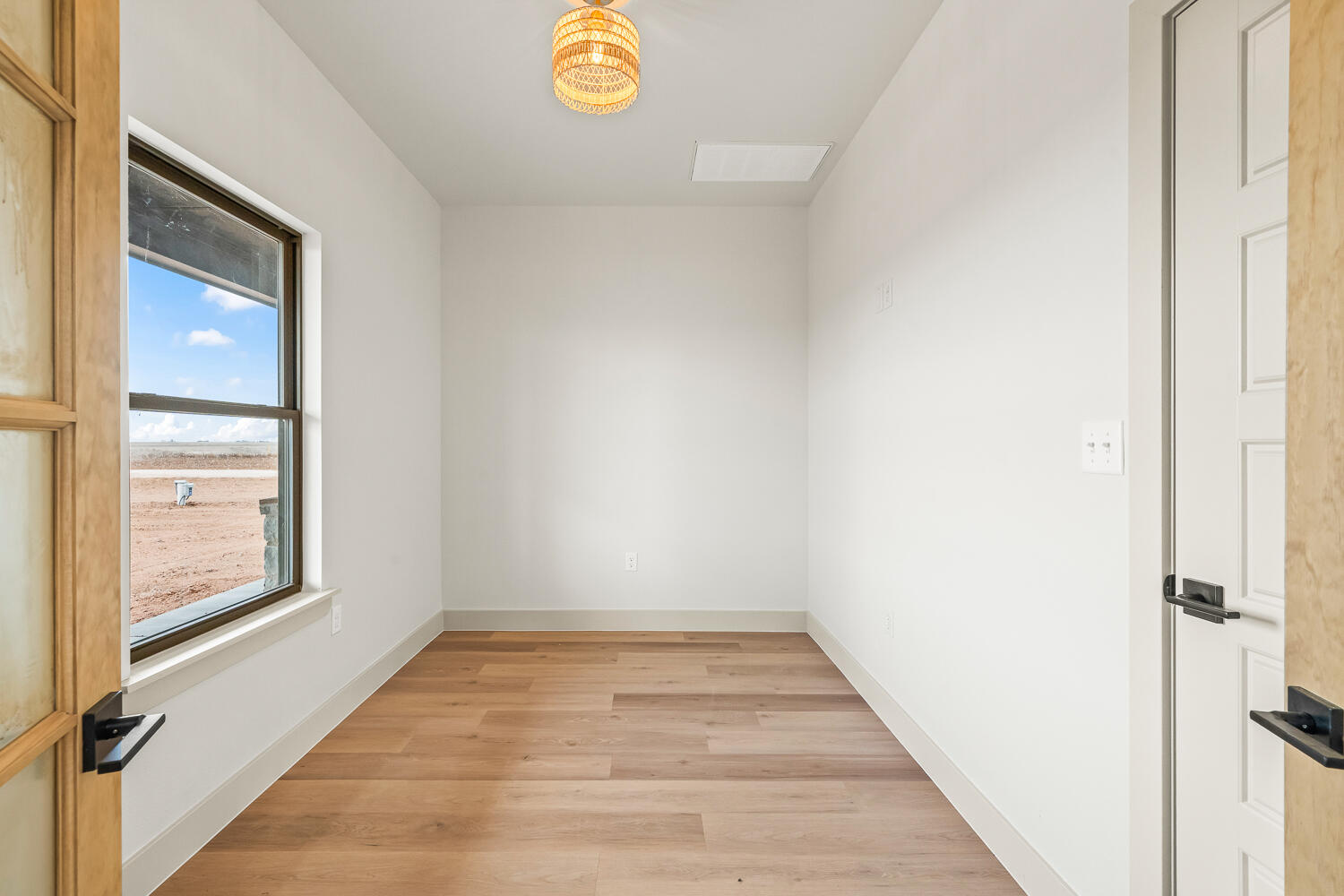 5603 County Road 6100 Lubbock, TX 79415 - Photo 13 of 46 an empty room with wooden floor and windows