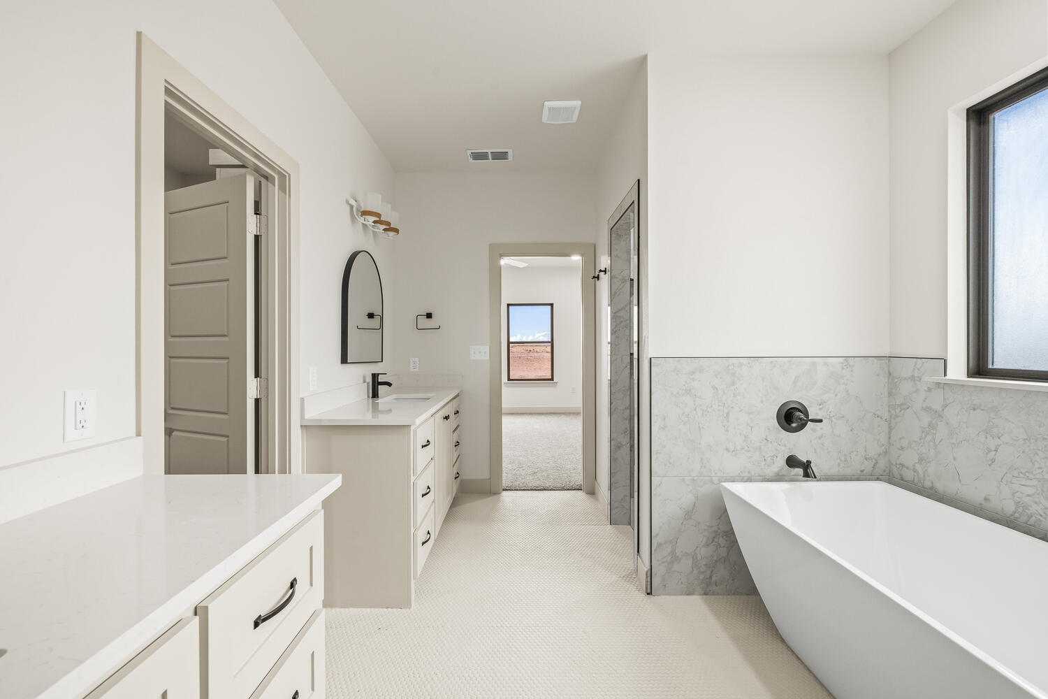 5603 County Road 6100 Lubbock, TX 79415 - Photo 25 of 46 a bathroom with a bathtub a mirror a double vanity sink and vanity