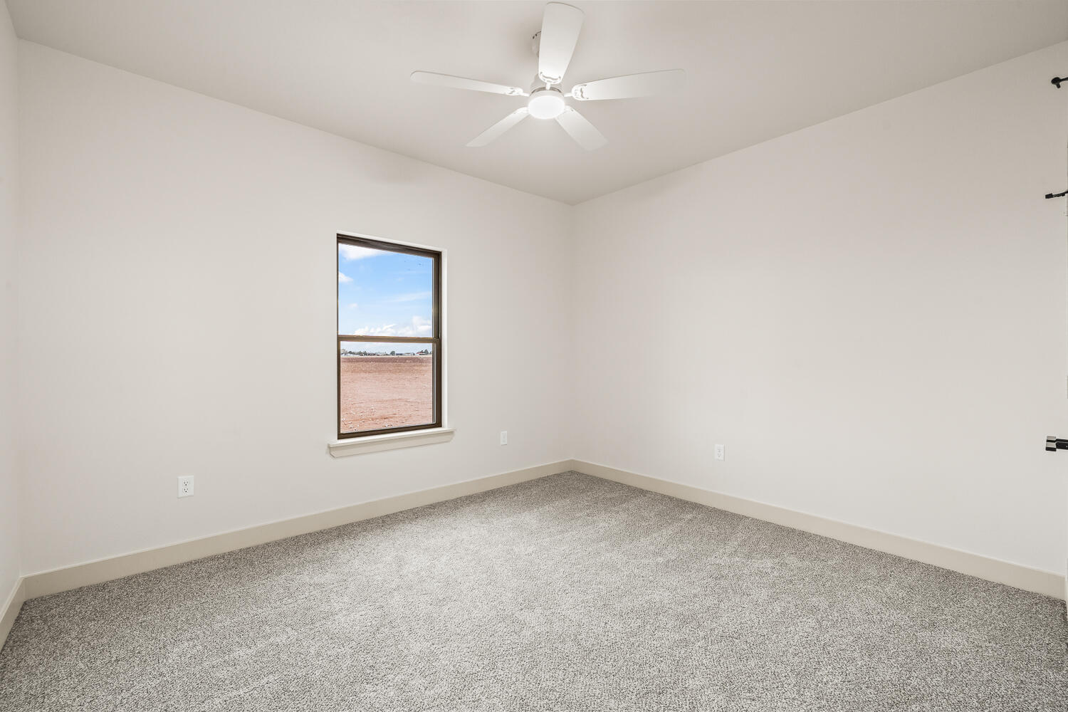5603 County Road 6100 Lubbock, TX 79415 - Photo 9 of 46 an empty room with a window and a fan
