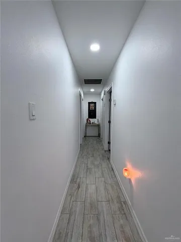 a view of hallway with wooden floor