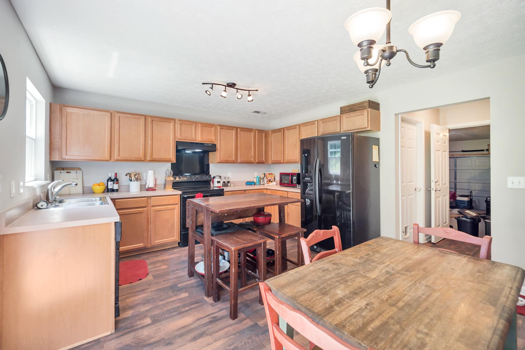3977 Stephens Ridge Way Antioch, TN 37013 - Photo 8 of 23 a open kitchen with stainless steel appliances granite countertop a refrigerator stove a sink dishwasher and a dining table with wooden floor