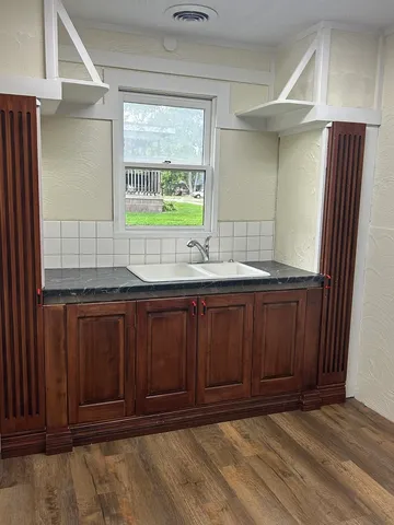 an empty room that has a large window and wooden floor
