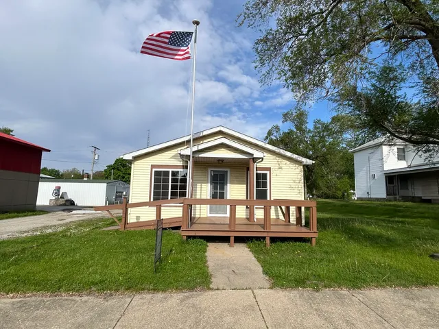 a front view of a house with a garden and trees
