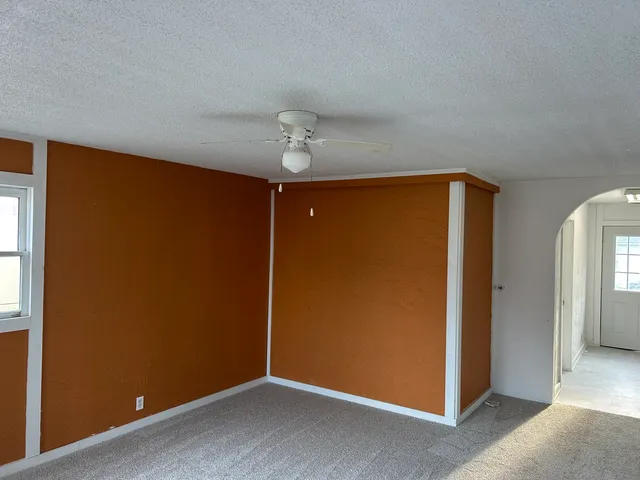 an empty room with chandelier fan