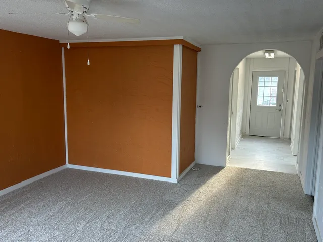 a view of a room with a glass door and a ceiling fan