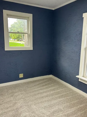 an empty room with wooden floor and cabinet