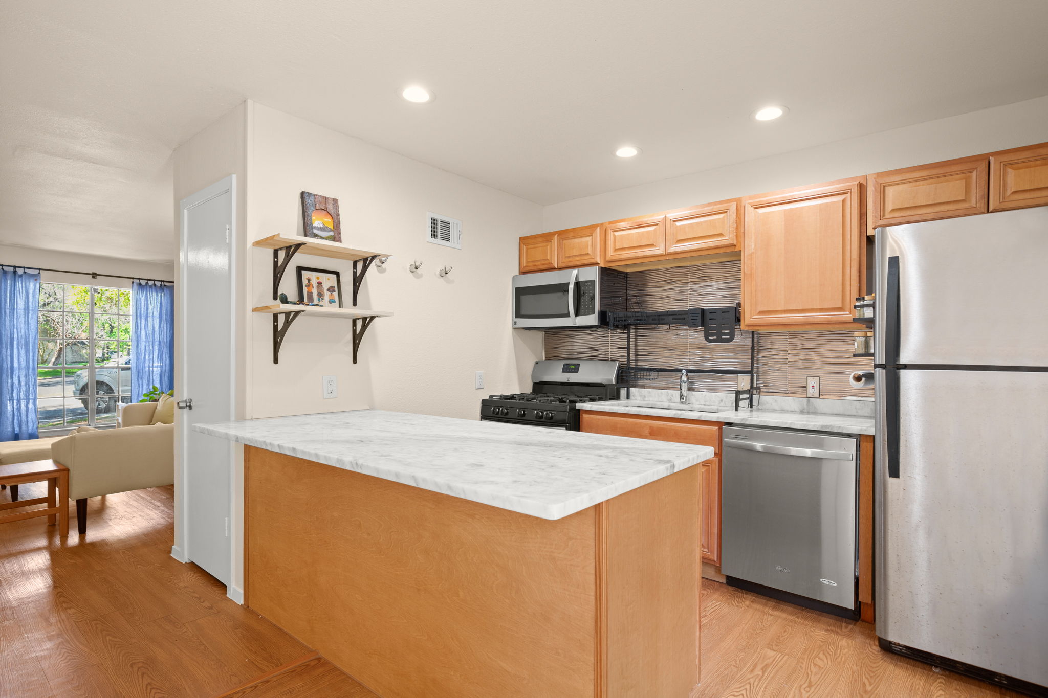1912 Lightsey Road, Unit 2 Austin, TX 78704 - Photo 4 of 25 a kitchen with stainless steel appliances granite countertop a refrigerator sink stove and white cabinets