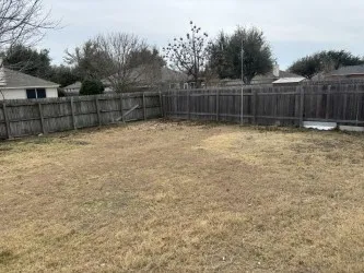 a view of a backyard with wooden fence