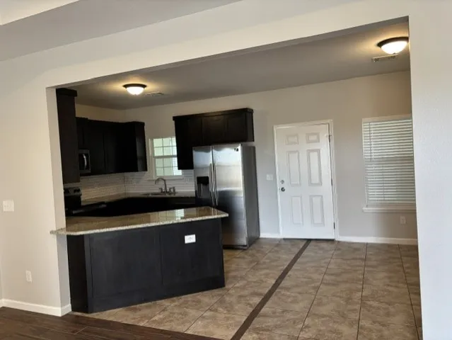 a kitchen with stainless steel appliances granite countertop a stove a sink and a refrigerator