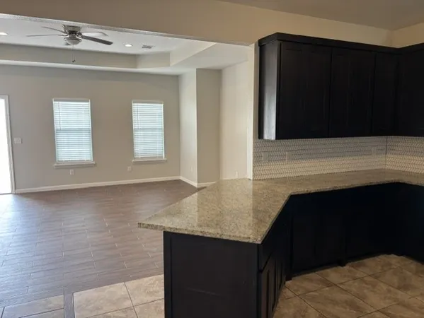 a kitchen with granite countertop white cabinets and black appliances