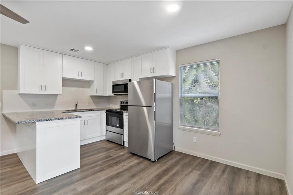 1504 Alpine Circle, Unit D College Station, TX 77840 - Photo 6 of 17 a kitchen with a refrigerator and a stove top oven