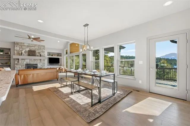 a living room with furniture large windows and wooden floor